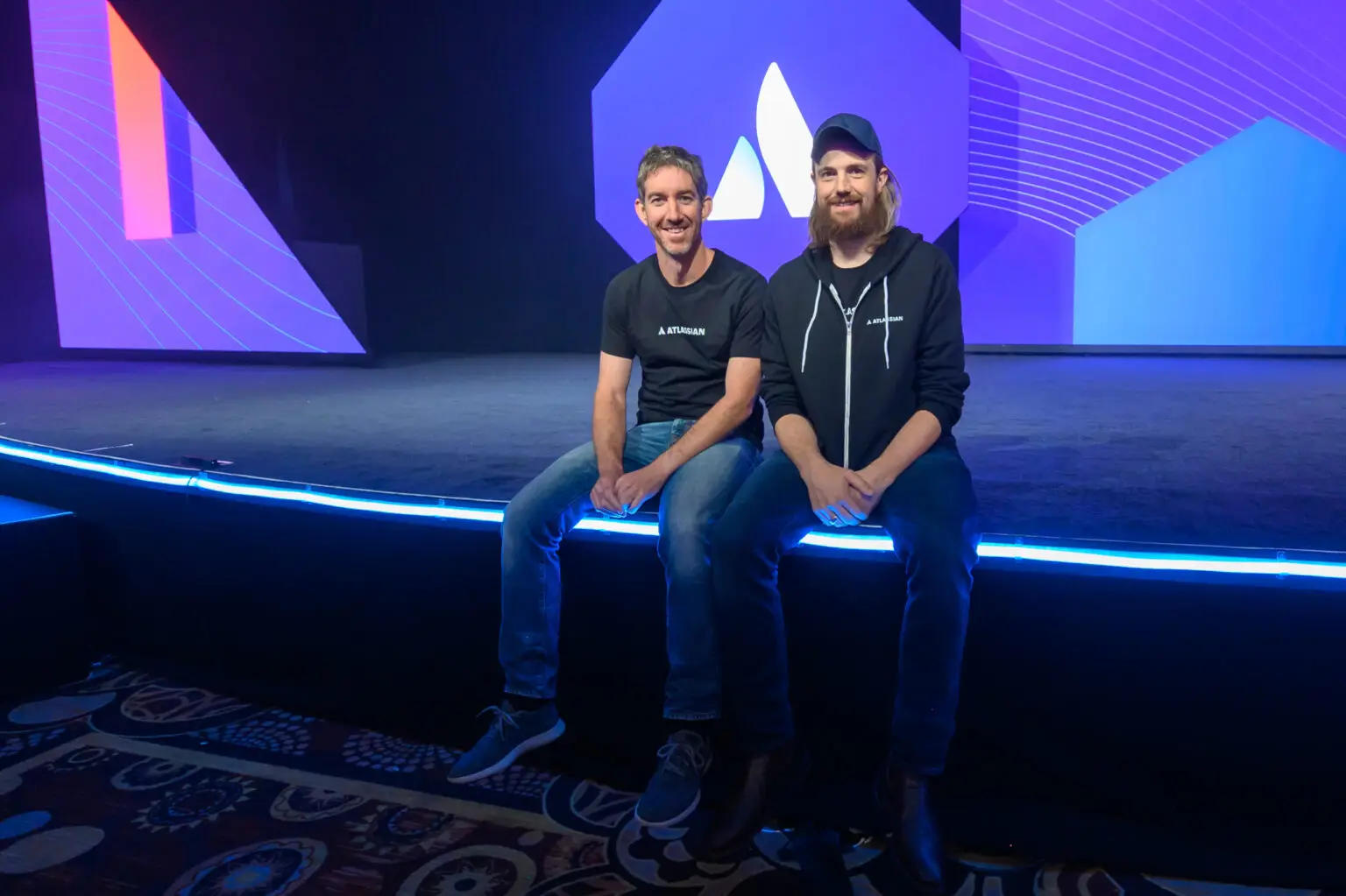 Die Geschichte von Atlassian beginnt mit einem bescheidenen Ziel: Mike Cannon-Brookes und Scott Farquhar wollten einfach nur traditionellen Bürojobs entkommen und mindestens so viel verdienen wie der durchschnittliche Hochschulabsolvent in Australien – damals etwa 48.500 AUD pro Jahr. Mit 10.000 AUD Startkapital, finanziert über ihre Kreditkarten, entwickelten sie ihr erstes Produkt: Jira, ursprünglich ein Tool für Bug-Tracking.