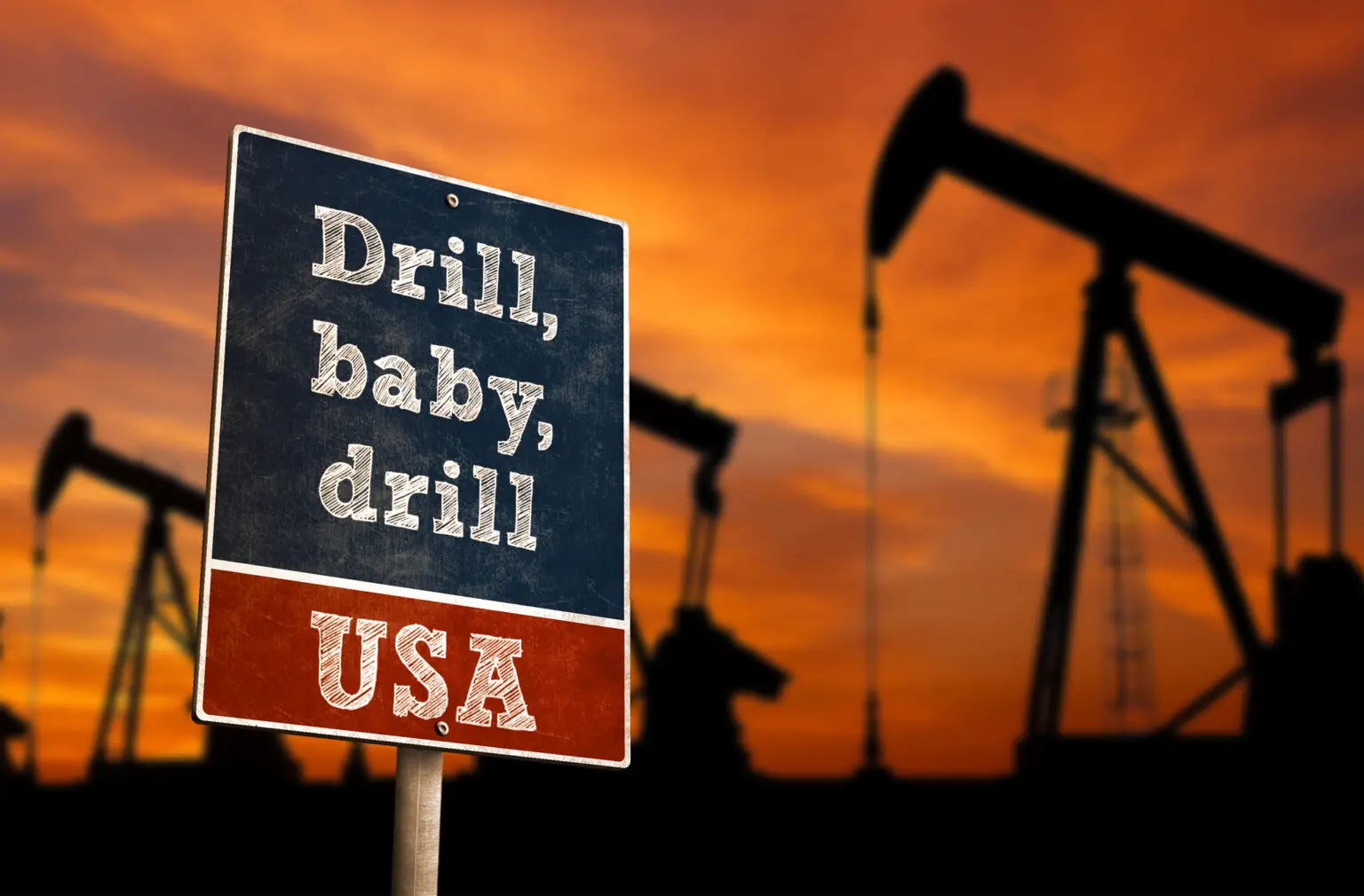 Öl-Pumpen, "Drill Baby"-Bohrer-Slogan mit Pumpen der Ölindustrie im Hintergrund